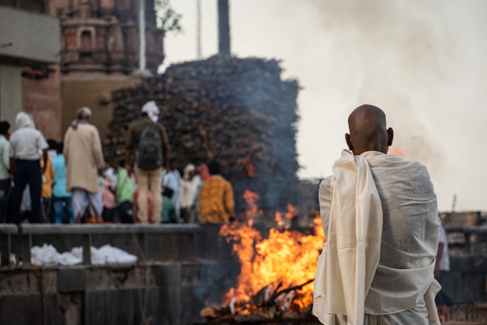 a man standing in front of a fire