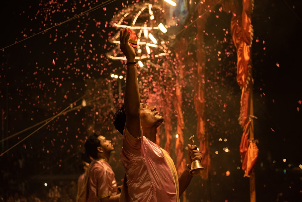 a man holding up a trophy in front of fireworks