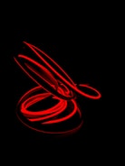 Abstract shot of red and white light trails against a black background.