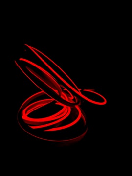 Abstract shot of red and white light trails against a black background.