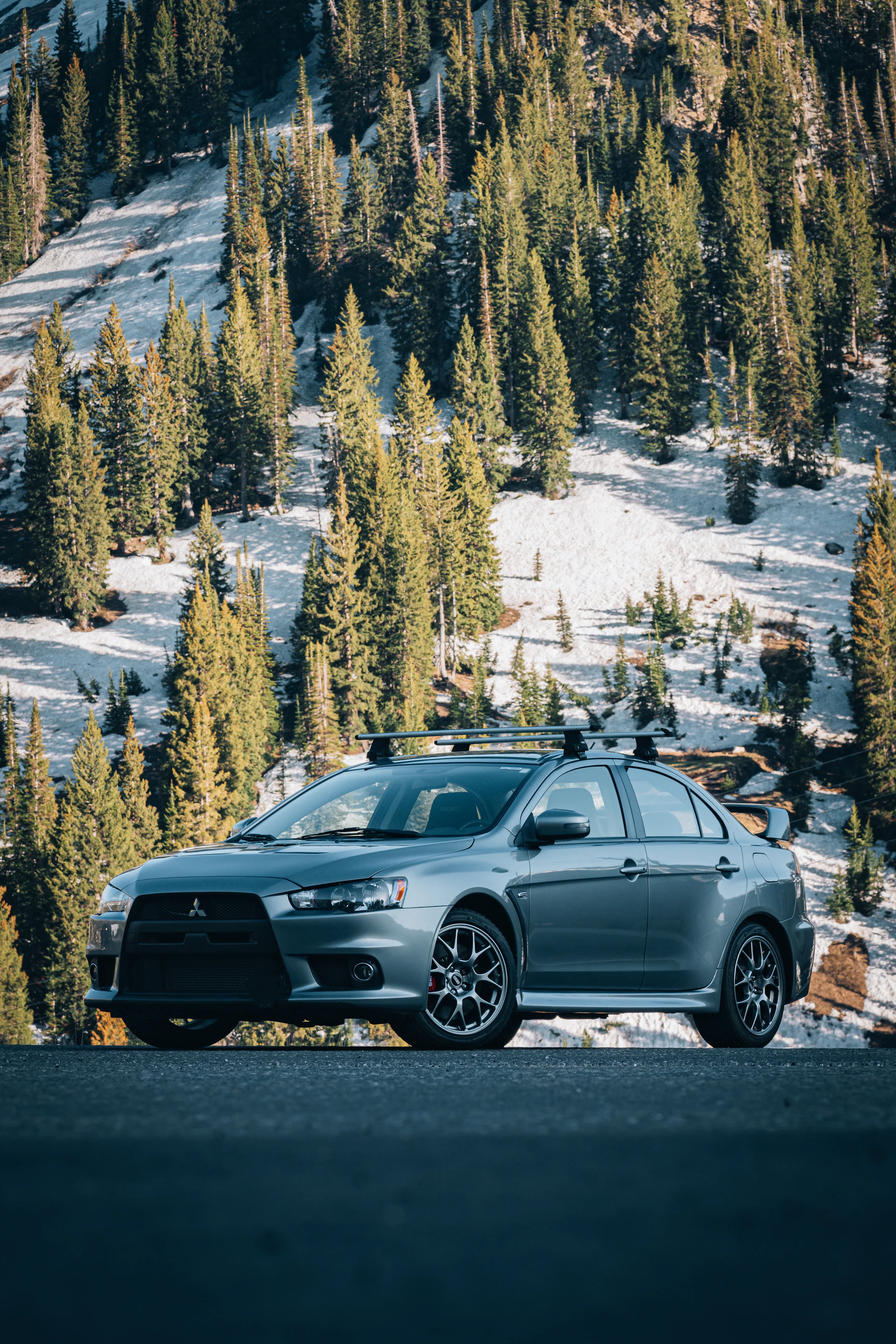 a car parked on the side of the road in front of a mountain