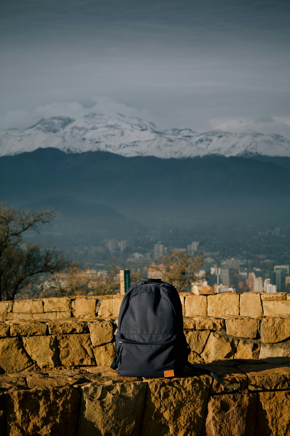 a backpack sitting on top of a stone wall