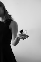 A cinematic black and white portrait of a model gently holding an Aurum bottle, highlighting timeless luxury.