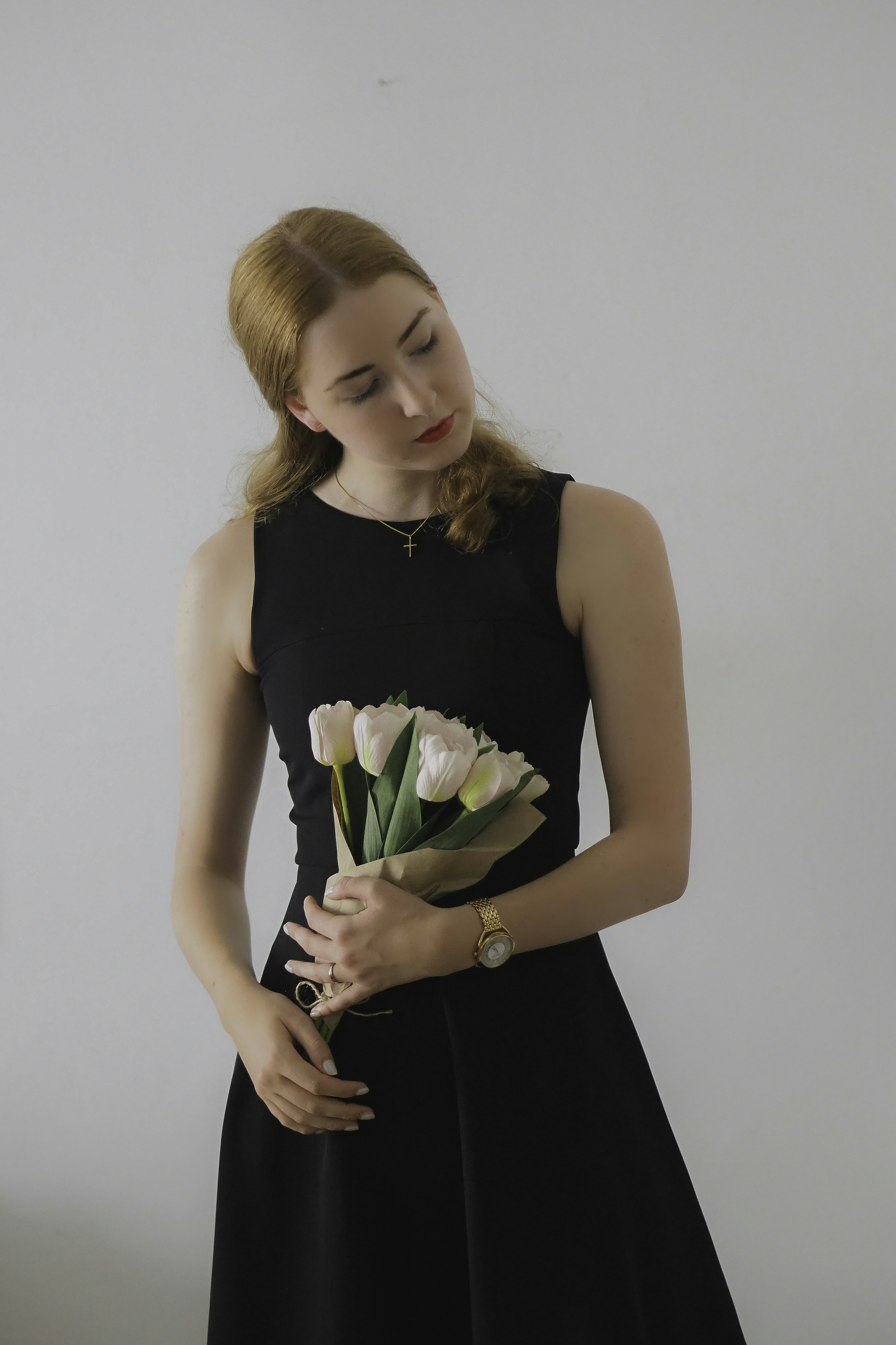 A woman in a black dress holding a bouquet of flowers photo  Free Woman  Image on Unsplash