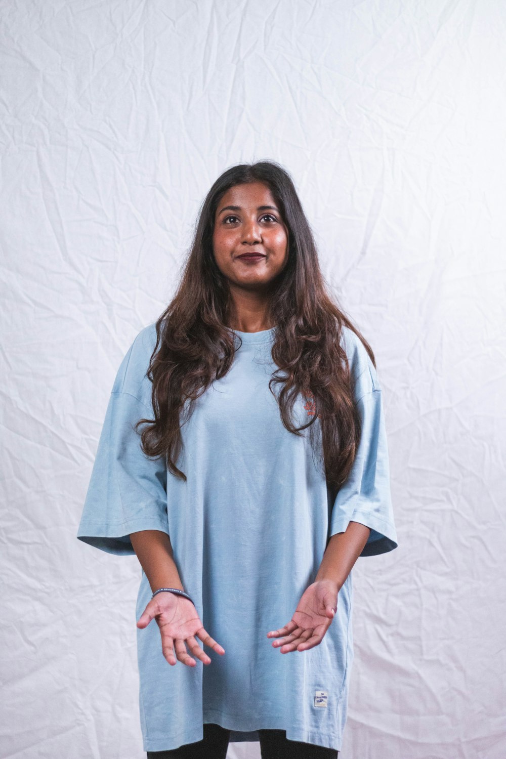 a woman standing in front of a white backdrop