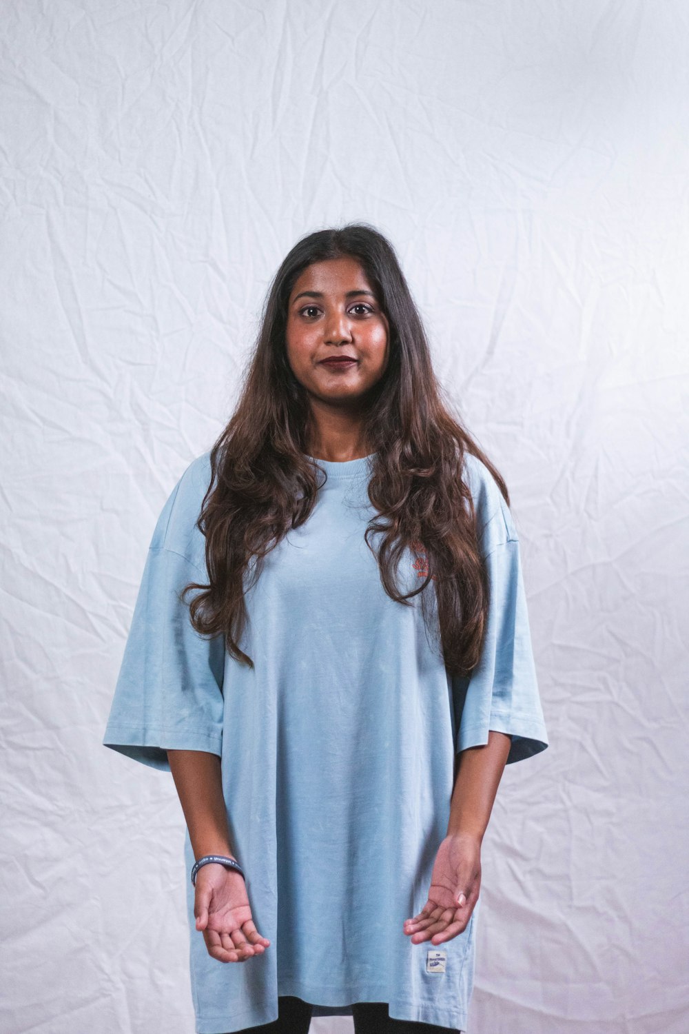 a woman standing in front of a white backdrop