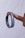 A hand holding a black lanyard or wristband between two fingers. The band has white text with the words 'external' and 'internal' printed on it. The background is a plain, light-colored backdrop.