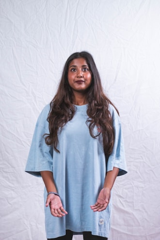 Model wearing a relaxed-fit oversized tee in a calm, neutral shade against a simple backdrop.