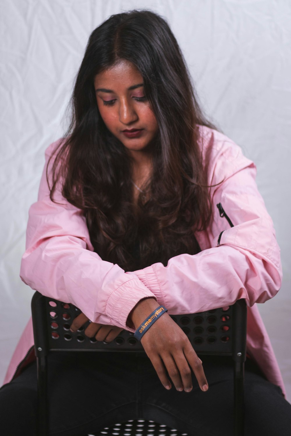 a woman sitting in a chair with her hands on her knees