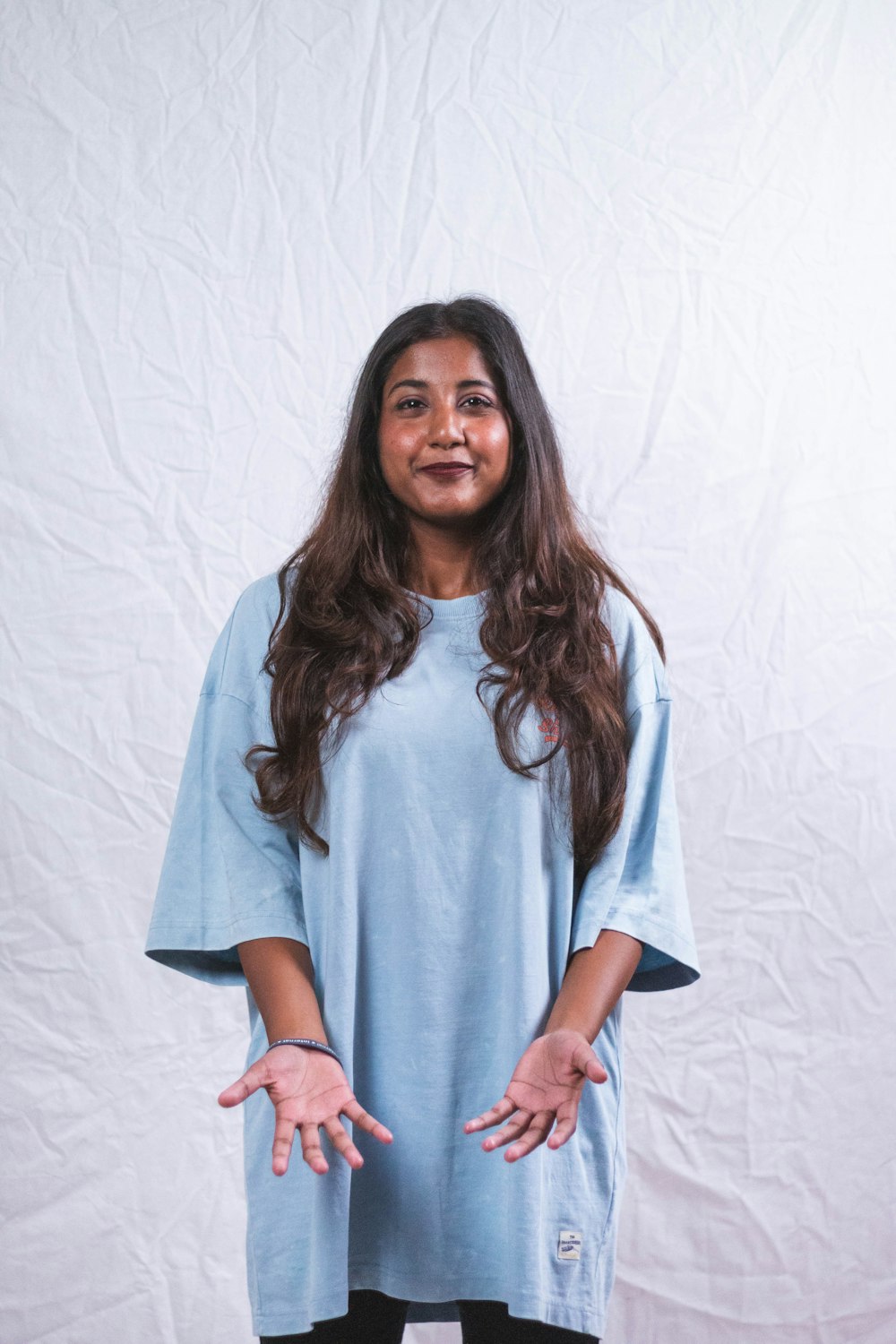 a woman standing in front of a white backdrop