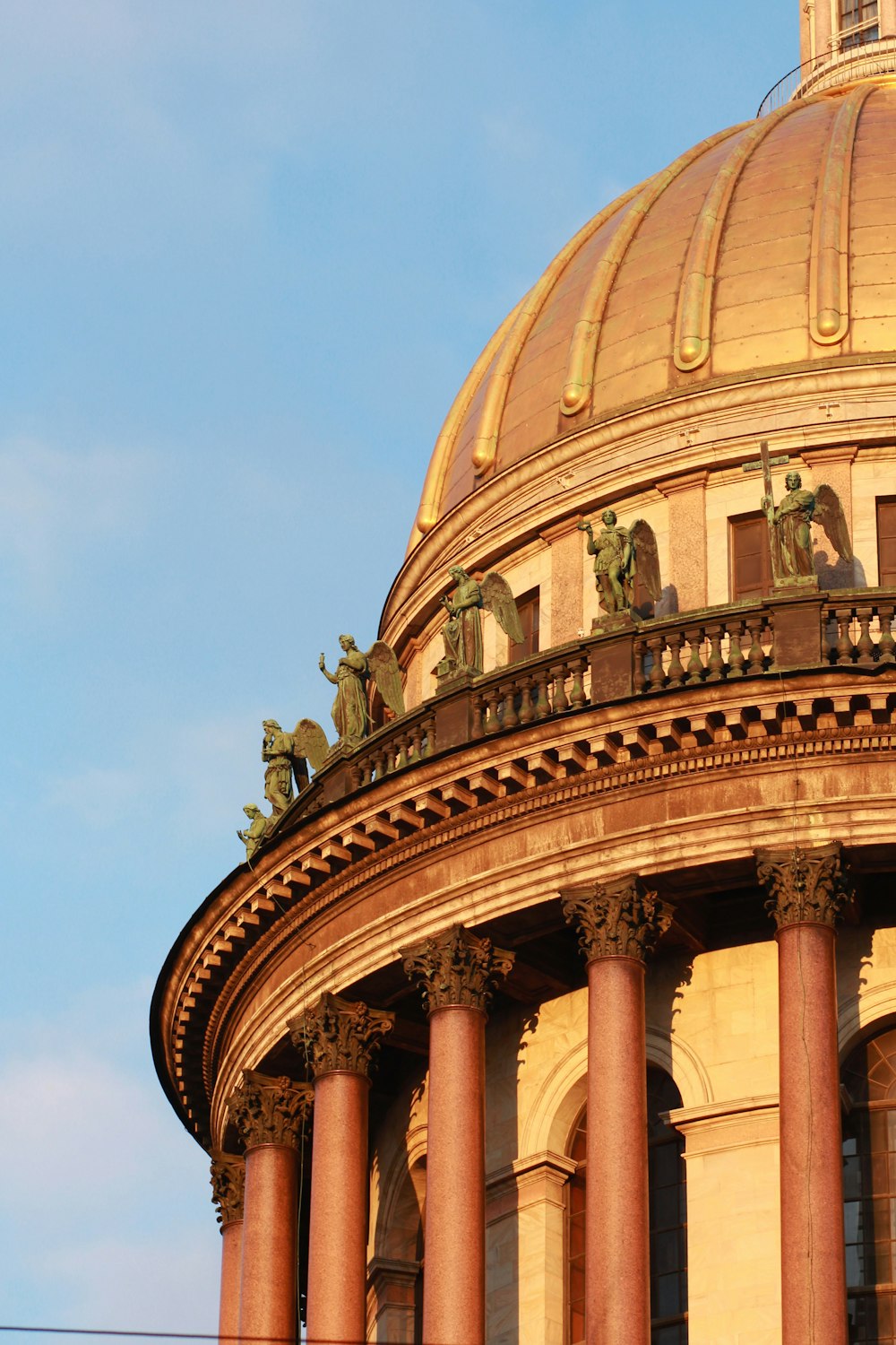 the dome of a building with statues on it