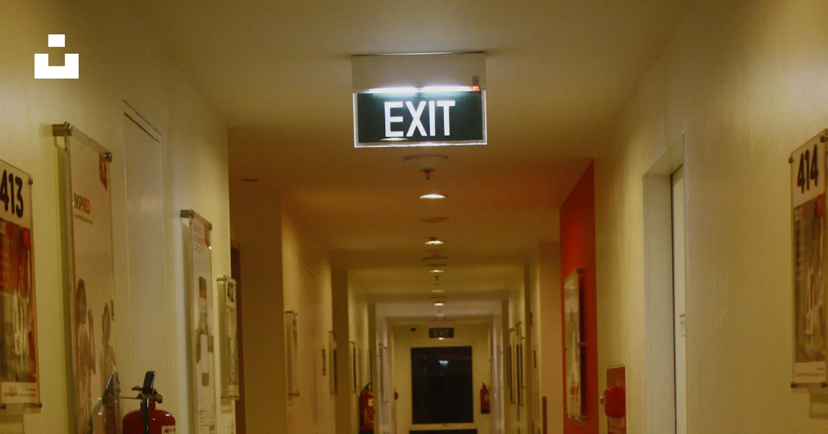 Exit Sign In Hall A long hallway with a exit sign on the wall photo – Free Hotel Image on ...