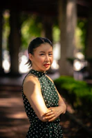 A confident plus-size woman smiling in a vibrant patterned dress outdoors.