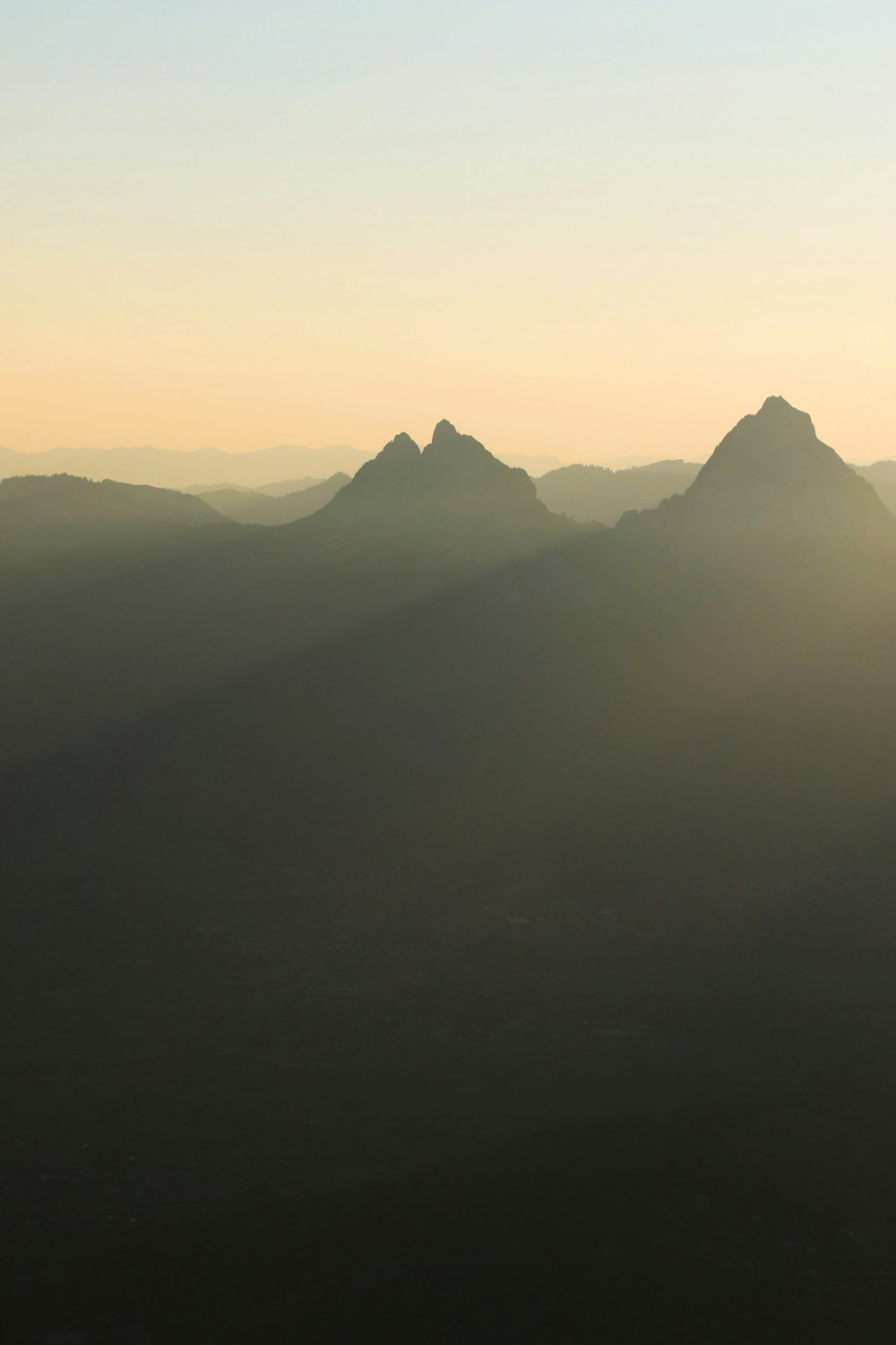 the sun is setting over the mountains in the distance