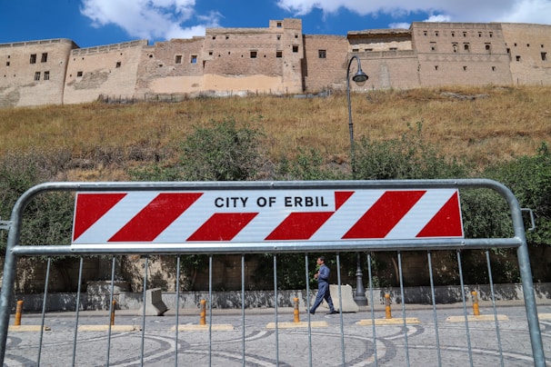Aerial view of Erbil city skyline with the iconic Citadel under a clear blue sky.
