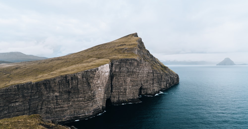 a large rock formation in the middle of a body of water