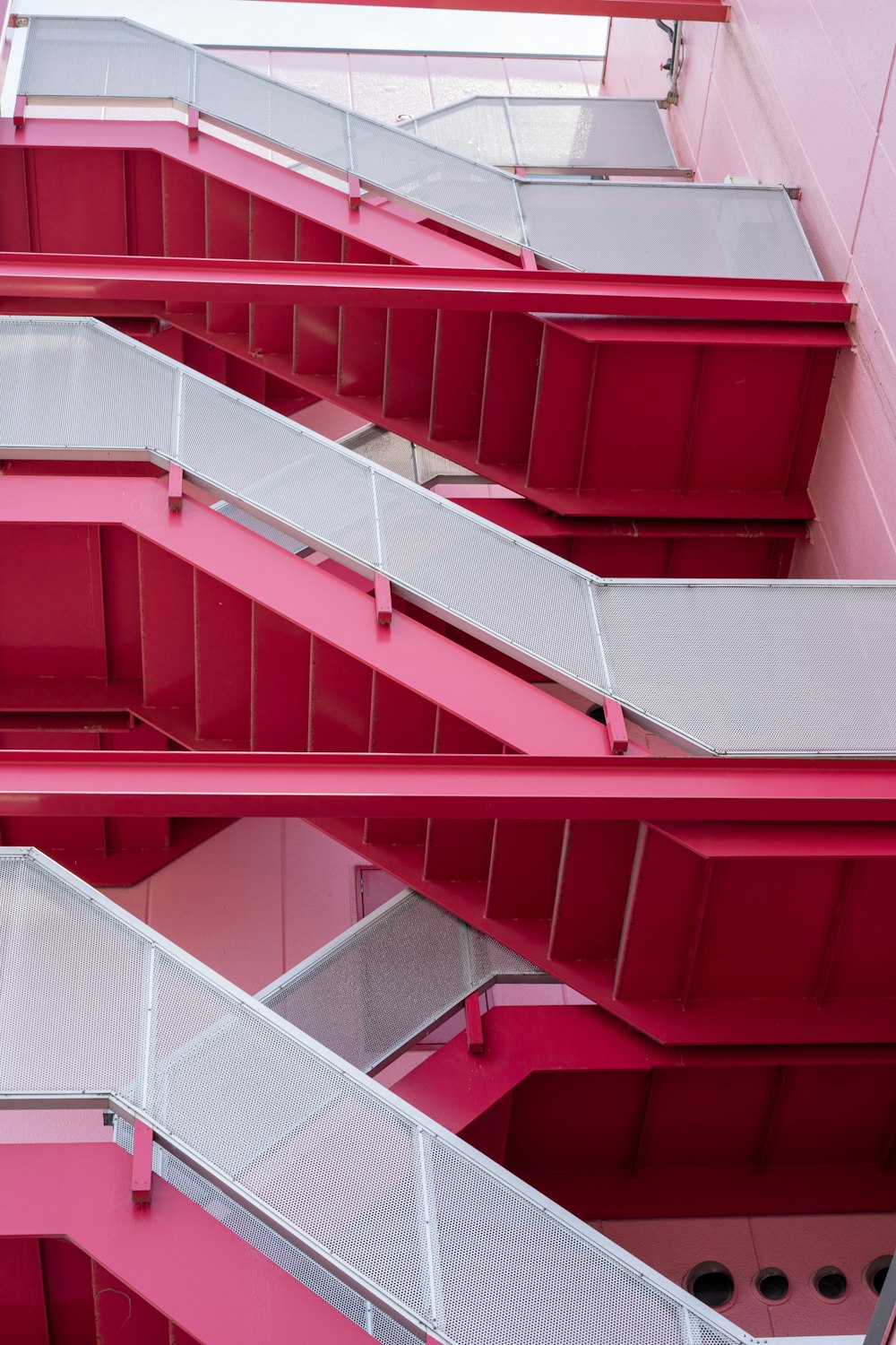 a pink building with a bunch of balconies
