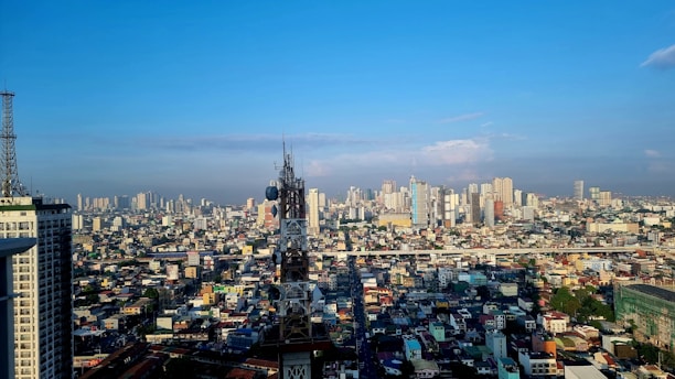 A dynamic collage showing office buildings, industrial machinery, and telecom towers under a clear sky.