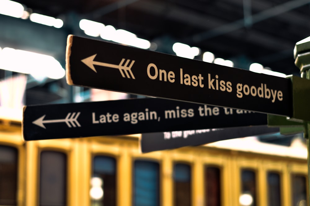 a street sign pointing in opposite directions at a train station