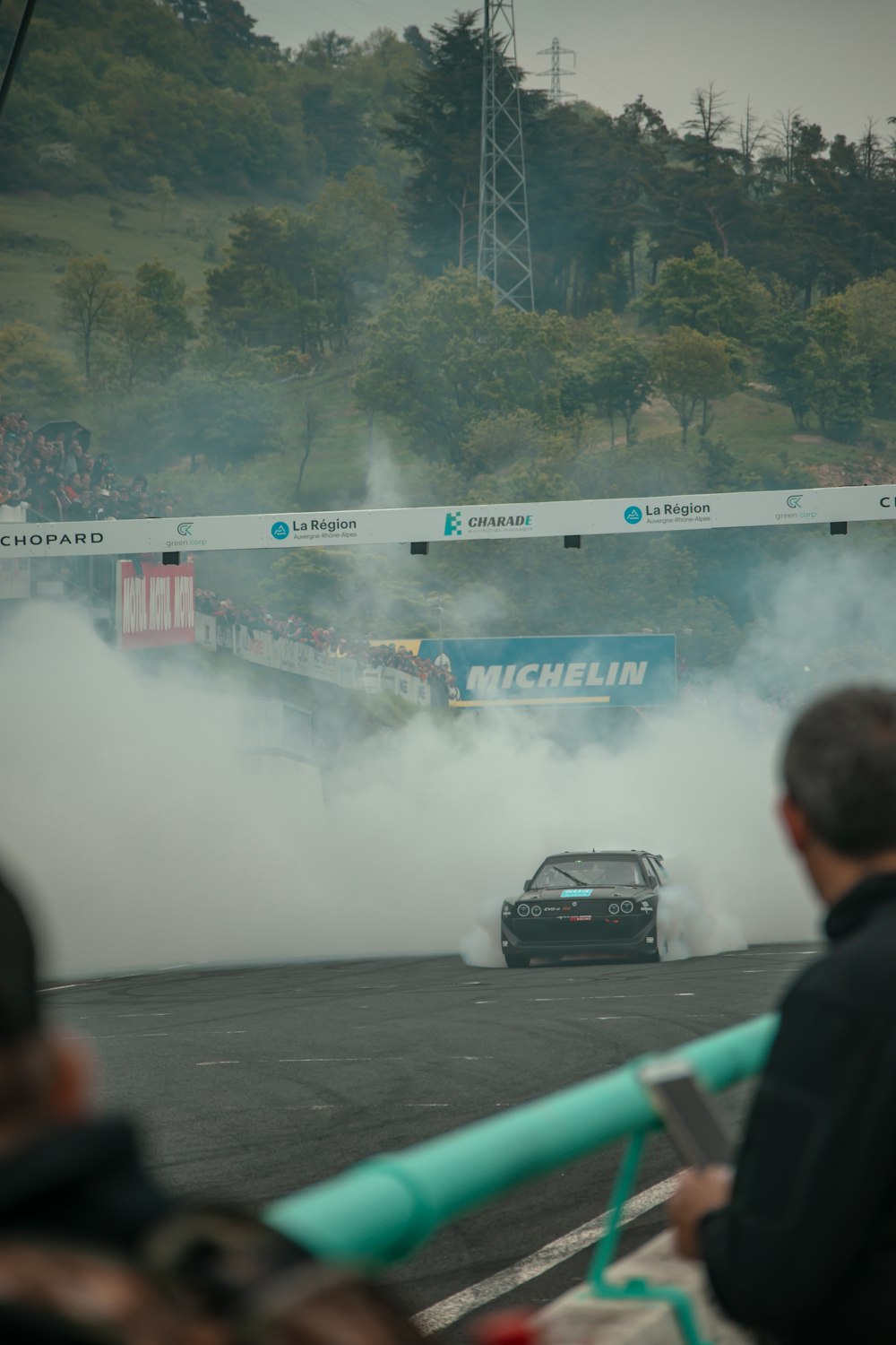 a car driving down a race track with smoke coming out of it