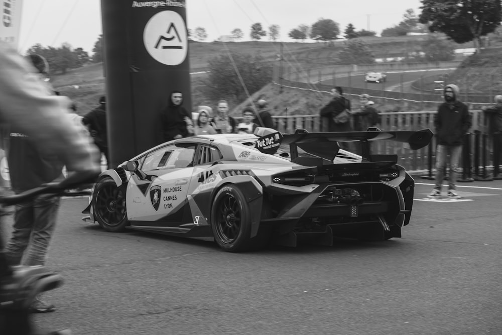 a man riding a bike past a race car