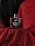 A bottle of Beardo Whisky Smoke eau de parfum is placed on red fabric. The background is a combination of black and red drapery, creating a dramatic and luxurious setting. The bottle has a sleek, rectangular design with a dark cap.
