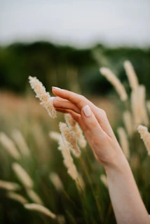 Hands gently touching the soft surface of artificial grass tiles.