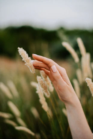Hands gently touching the soft surface of artificial grass tiles.
