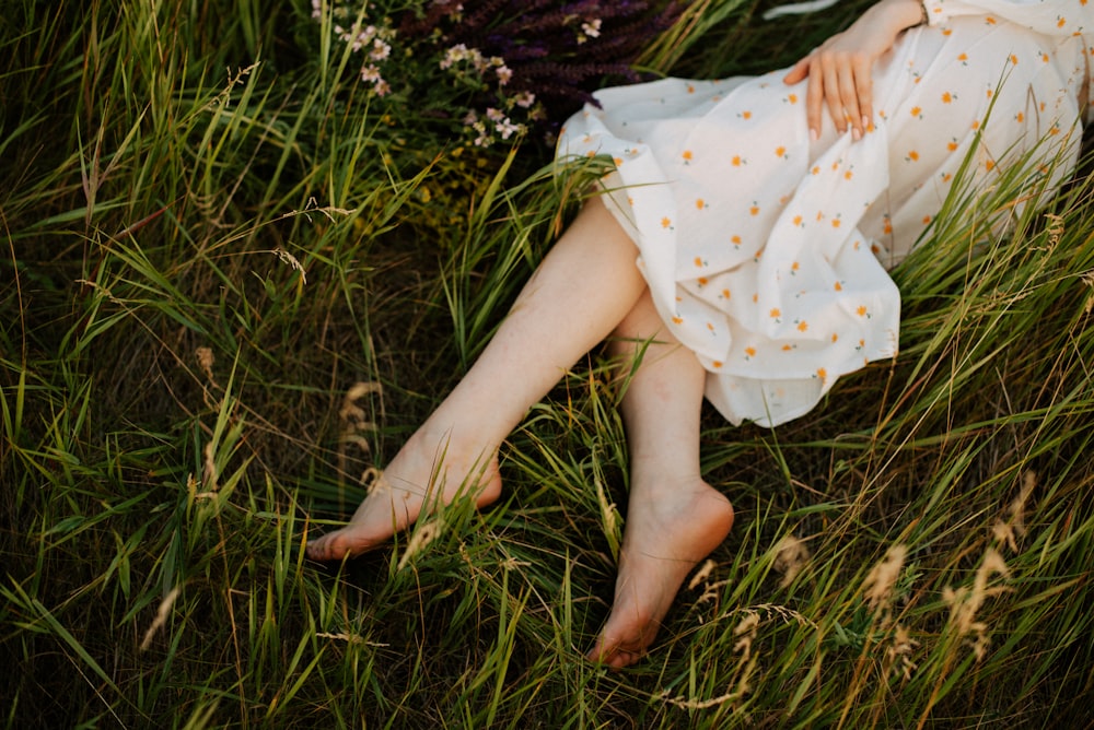 a woman laying in a field of tall grass