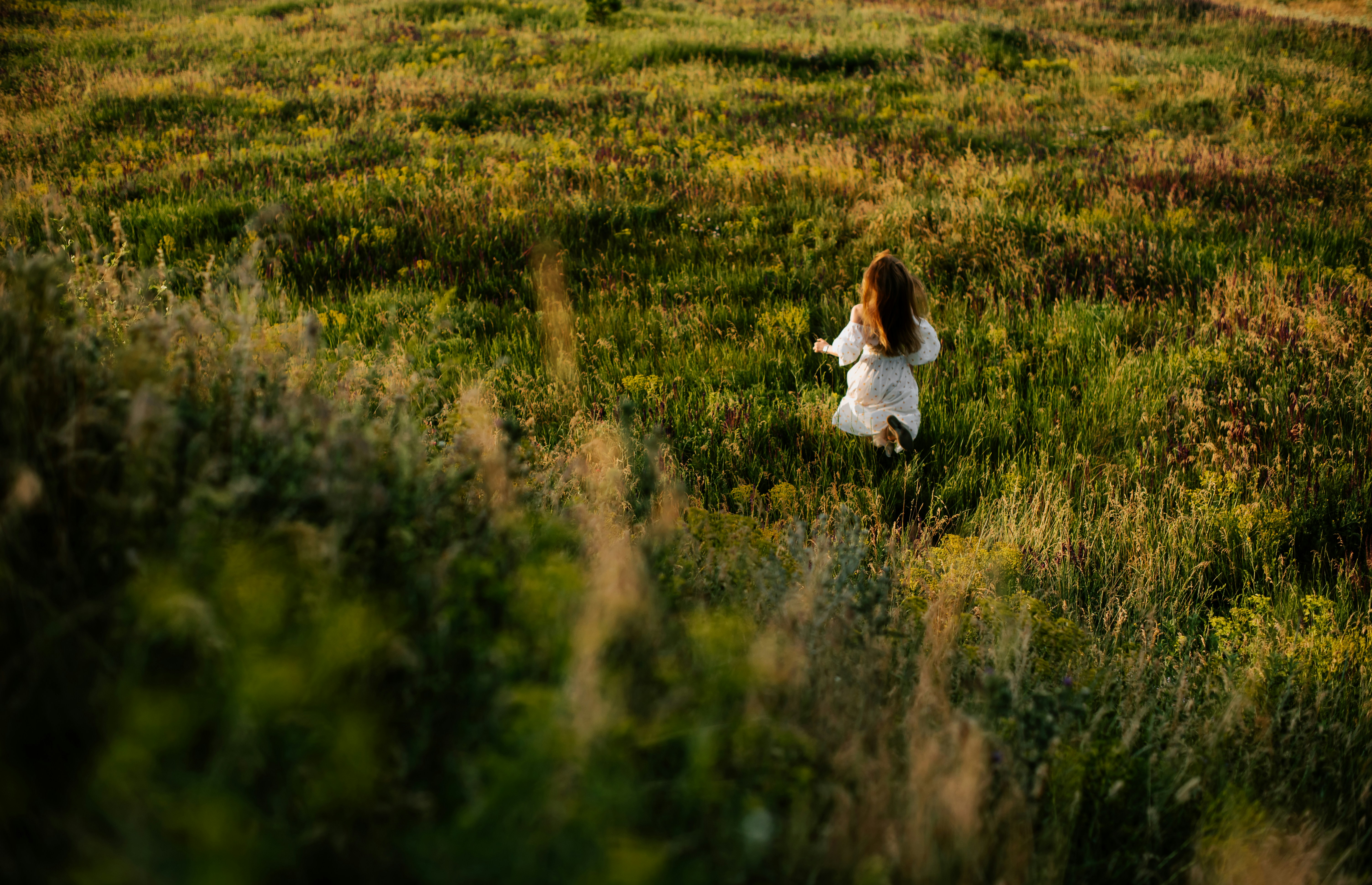 a girl in a field of tall grass