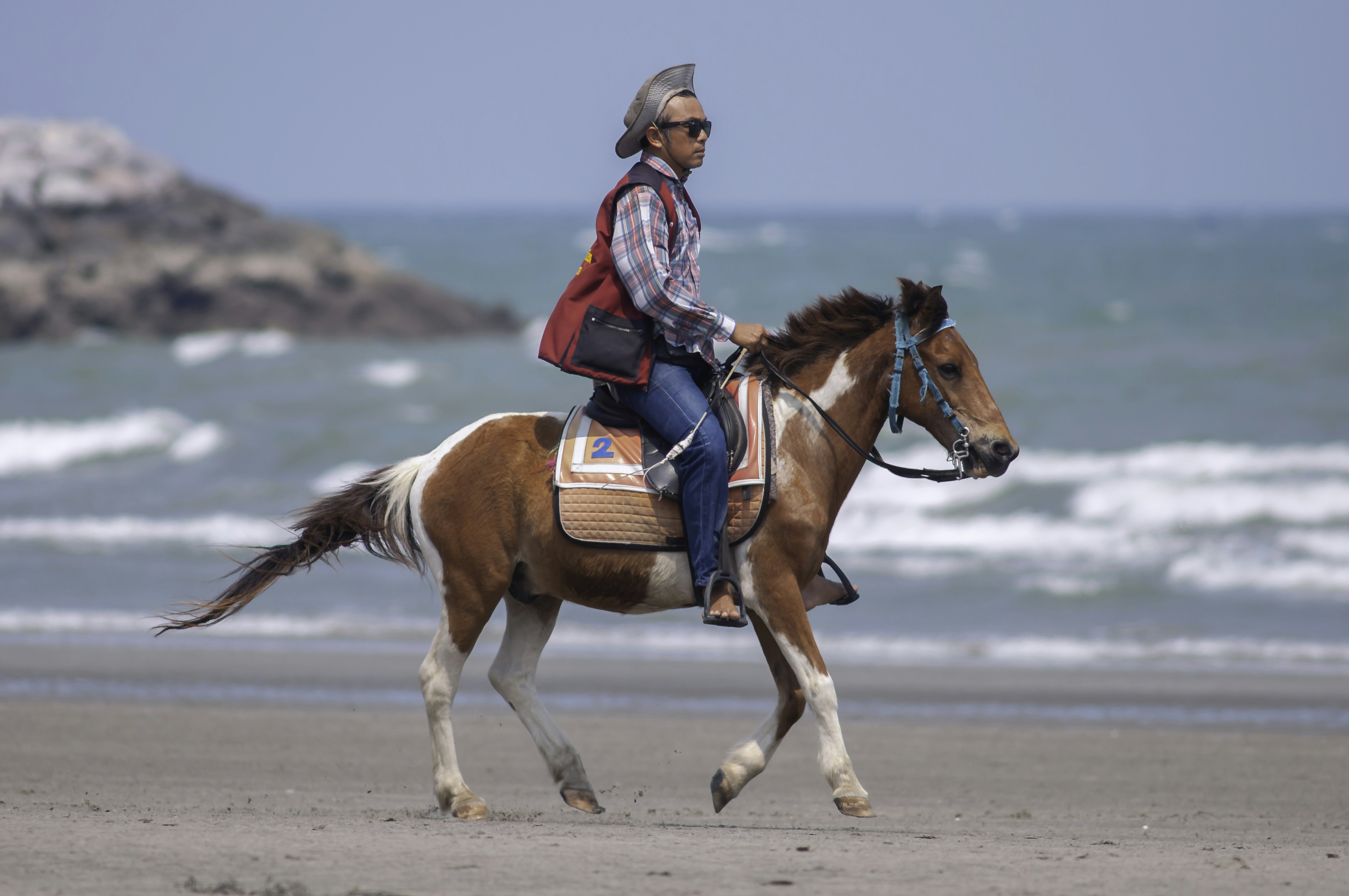 a person riding a horse on a beach