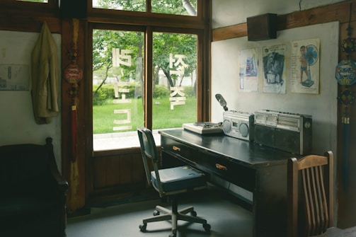 a room with a desk, chair and a window