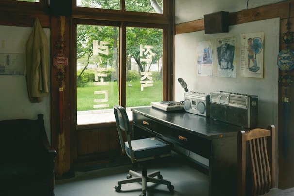 a room with a desk, chair and a window