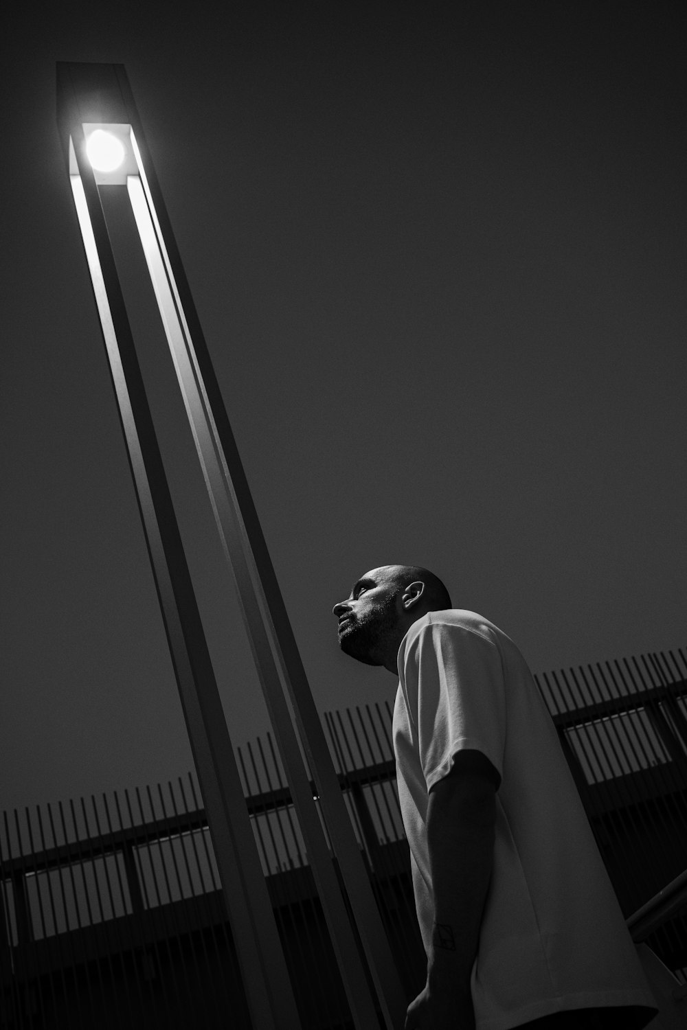 a man standing next to a tall light pole