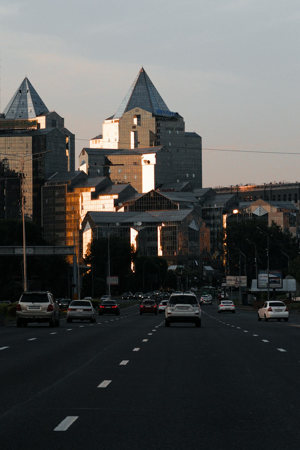 a city street filled with lots of traffic next to tall buildings