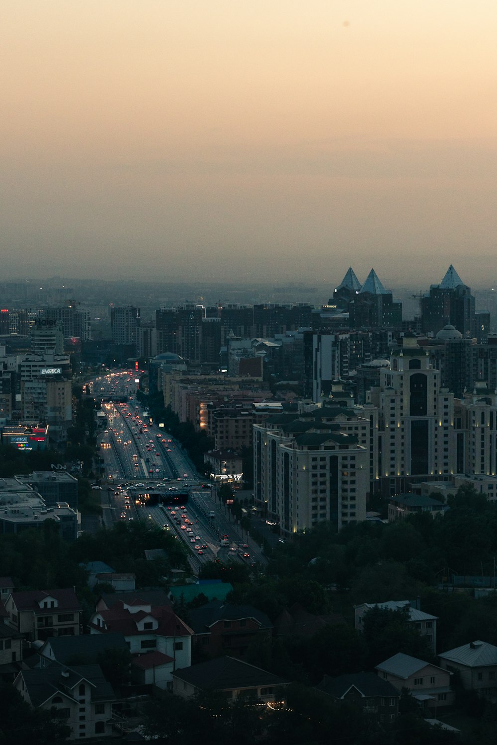a view of a city at dusk from the top of a hill