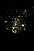 Evening cityscape with illuminated buildings and busy streets.