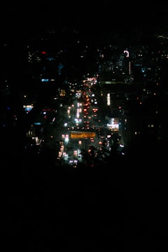 City skyline at night with illuminated buildings and busy streets.