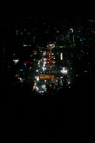 An evening skyline of a major city with illuminated buildings and busy streets.