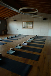 A serene yoga studio bathed in natural light with a calm instructor guiding a student.