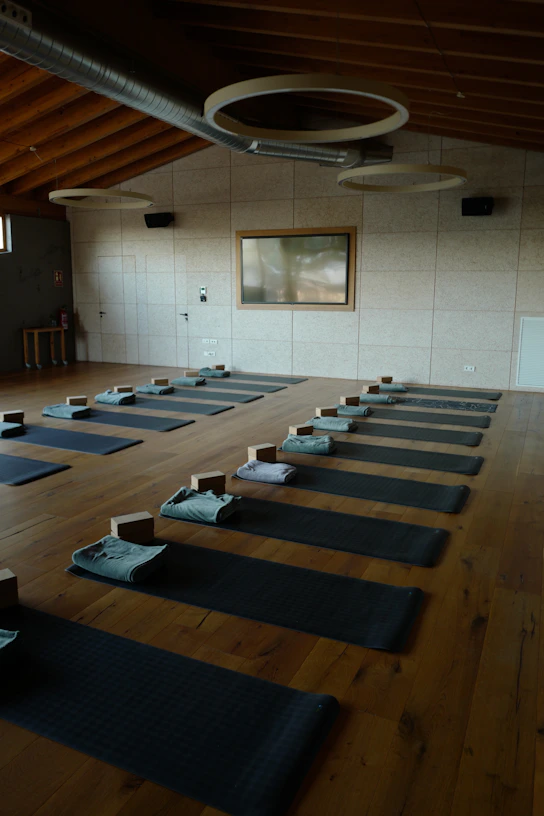 A serene yoga studio room bathed in natural light with mats arranged thoughtfully, inviting calm and connection.