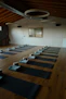 A peaceful yoga studio corner with mats and cushions bathed in warm natural light.