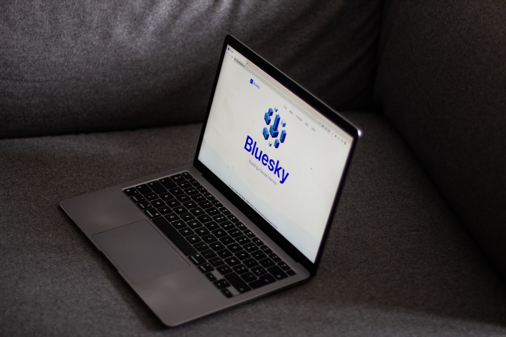 a laptop computer sitting on top of a gray couch