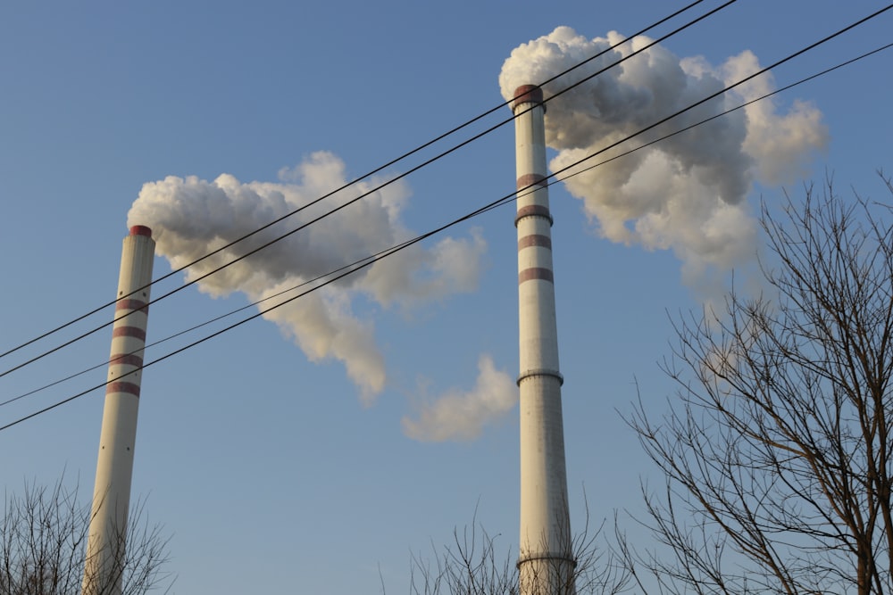 two smoke stacks emitting from the tops of power lines