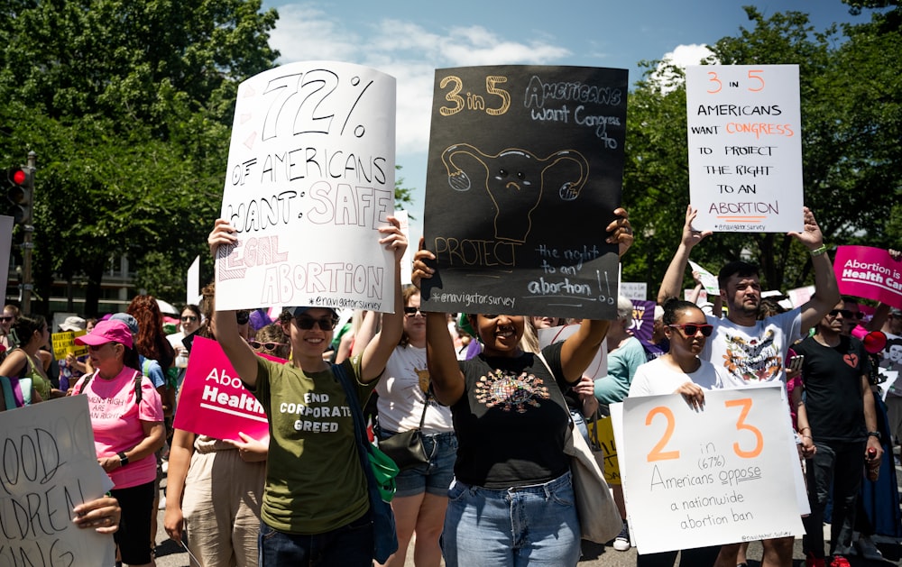 a group of people holding up signs in the street