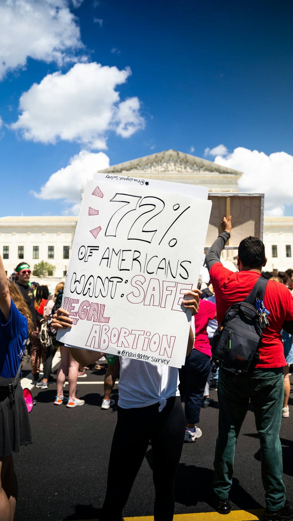 a group of people holding a sign in front of a building