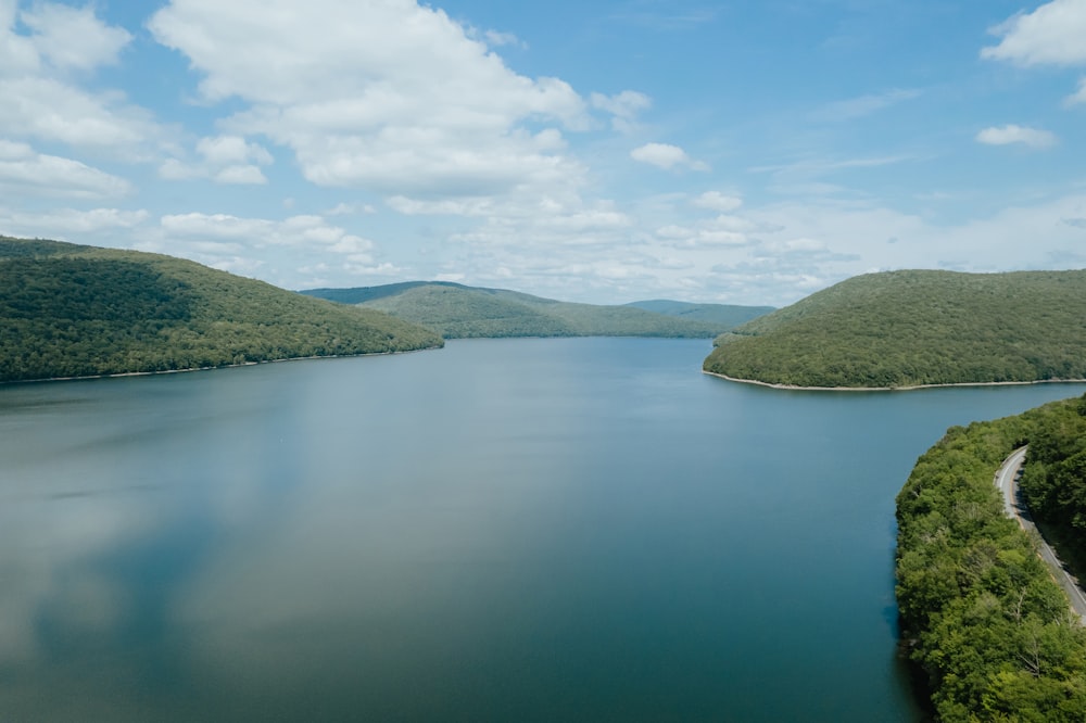 a large body of water surrounded by lush green hills