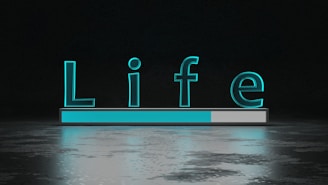 The word 'Life' is displayed in large, glowing teal letters above a horizontal progress bar that is partially filled. The background is dark with a reflective surface below the text and bar, creating a sense of depth and modernity.