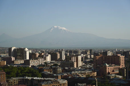 Modern Swiss mountain and city skyline blending harmoniously under clear blue sky.
