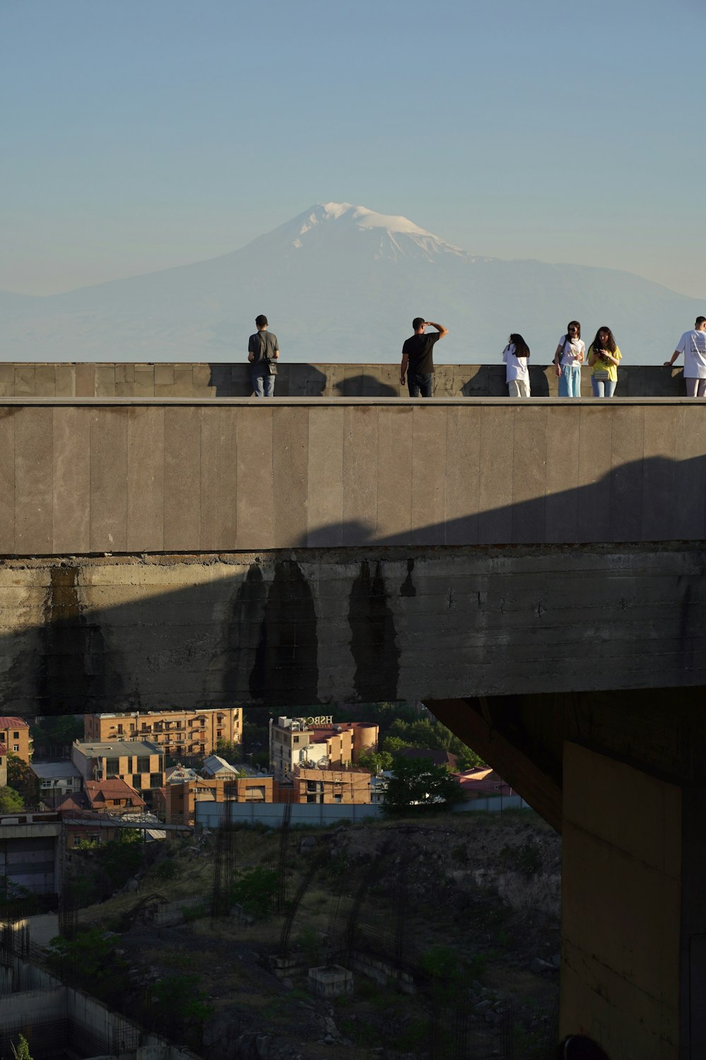 a group of people standing on top of a bridge